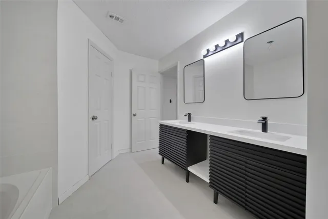 a spacious bathroom with a double vanity sink a mirror and shower