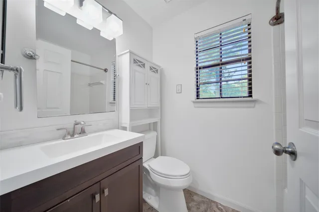 a bathroom with a sink a toilet and shower