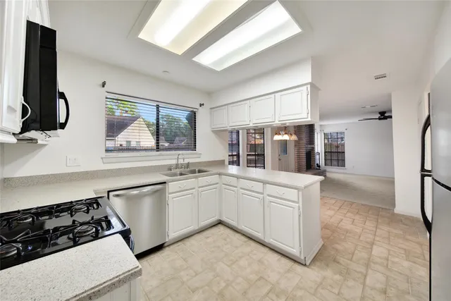 a kitchen with white cabinets and appliances