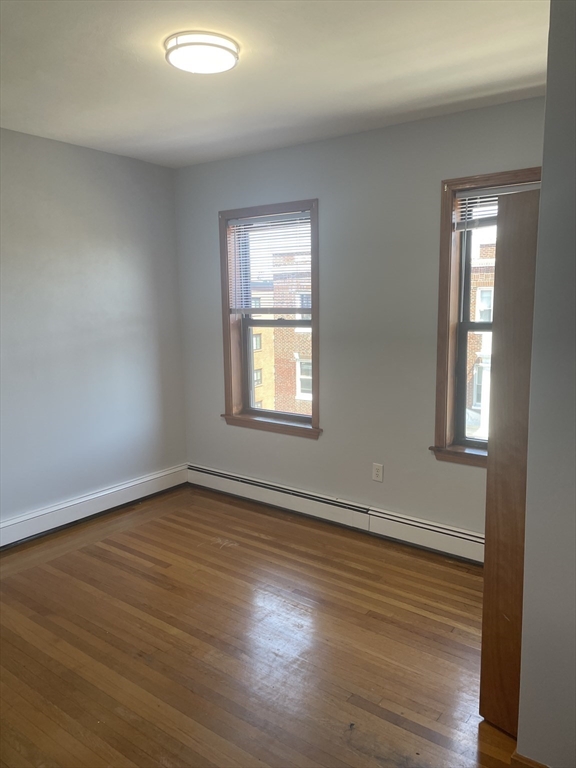 324 Summit Avenue, Unit 3 Boston, MA 02135 - Photo 4 of 16 a view of an empty room with wooden floor and a window