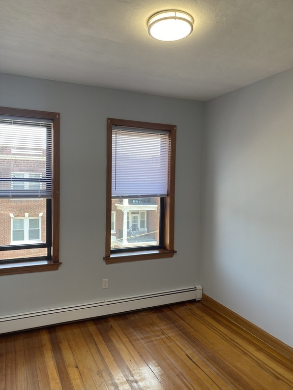 324 Summit Avenue, Unit 3 Boston, MA 02135 - Photo 6 of 16 a view of an empty room with wooden floor and a window