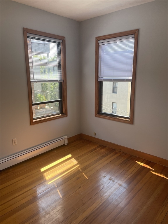 324 Summit Avenue, Unit 3 Boston, MA 02135 - Photo 10 of 16 an empty room with wooden floor and windows