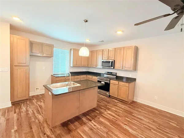 a kitchen with stainless steel appliances granite countertop a sink stove and wooden floor