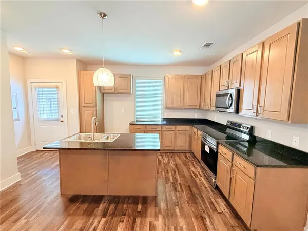 a kitchen with stainless steel appliances granite countertop a stove a sink and a microwave