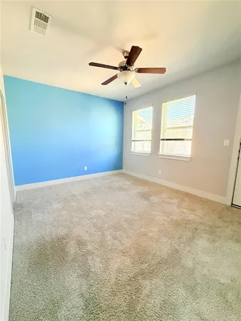 en empty room with windows and ceiling fan view