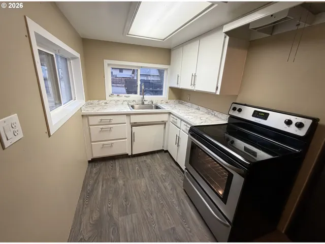 a kitchen with a stove and white cabinets