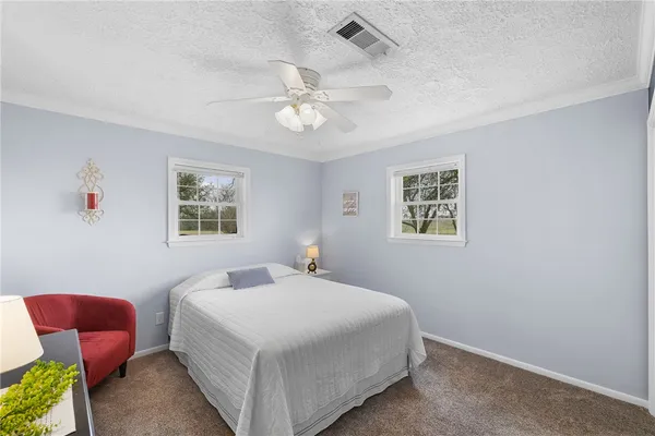a bedroom with a bed and a table in it with window