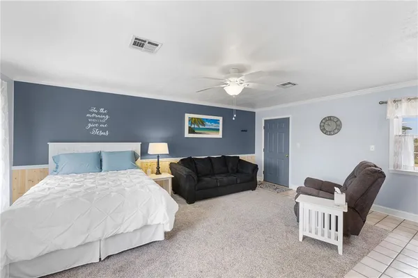 a bedroom with a bed and a lamp with the dresser
