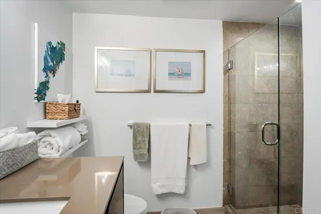 a bathroom with a granite countertop sink a toilet and shower