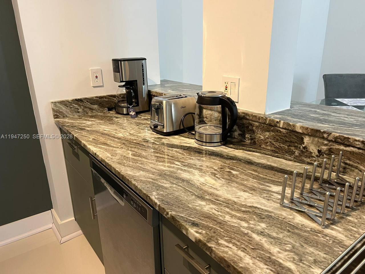 17100 North Bay Road, Unit 1509 Sunny Isles Beach, FL 33160 - Photo 11 of 21 a kitchen with a sink and a stove top oven