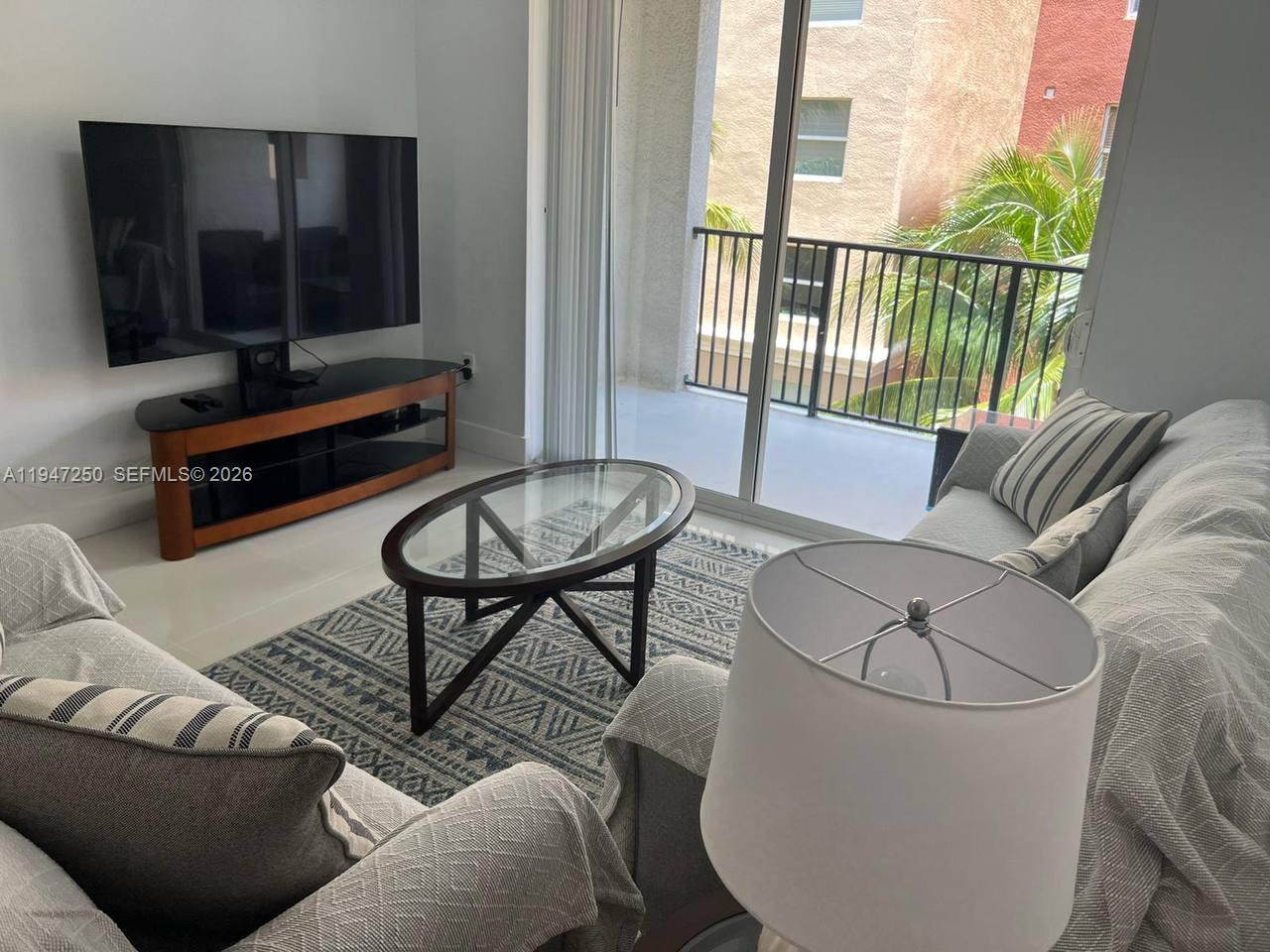 17100 North Bay Road, Unit 1509 Sunny Isles Beach, FL 33160 - Photo 3 of 21 a living room with furniture and a flat screen tv
