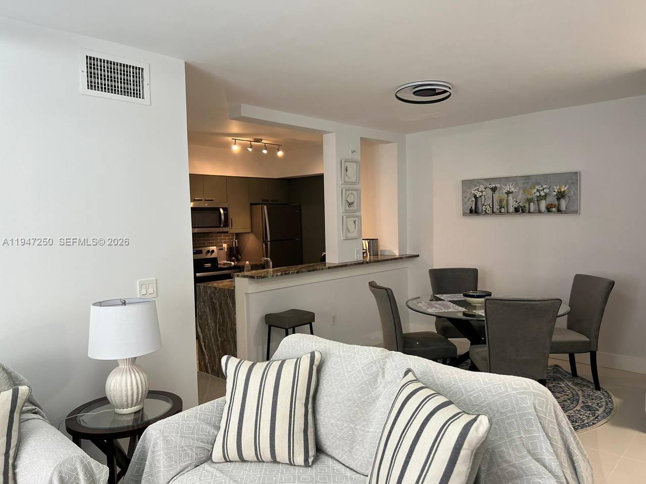 17100 North Bay Road, Unit 1509 Sunny Isles Beach, FL 33160 - Photo 6 of 21 a living room with a couch and a view of kitchen