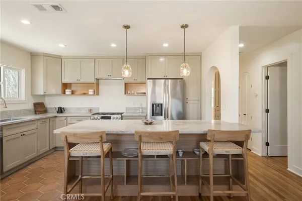 a kitchen with stainless steel appliances granite countertop a kitchen island a stove a table and chairs