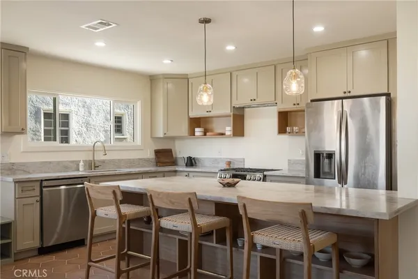 a kitchen with granite countertop a table chairs stove and microwave