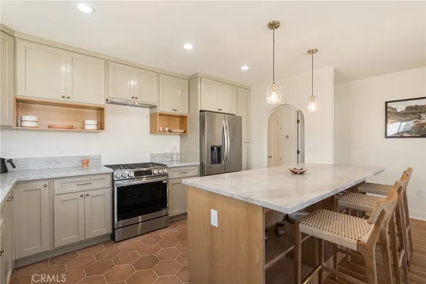 a kitchen with stainless steel appliances granite countertop a stove a sink and a microwave
