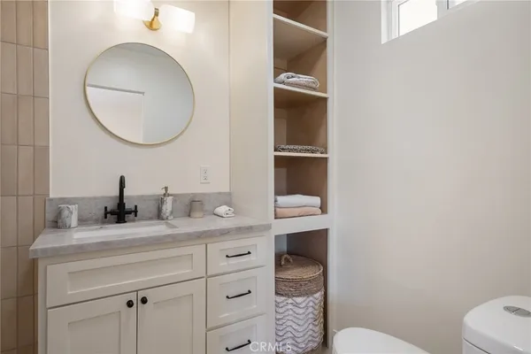 a bathroom with a granite countertop sink and a mirror