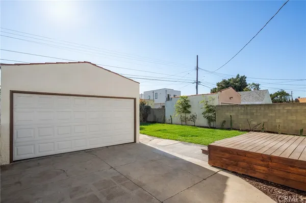 a view of a backyard with potted plants and large tree