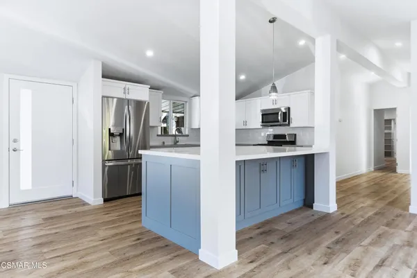 a kitchen with stainless steel appliances granite countertop a refrigerator a stove and a sink