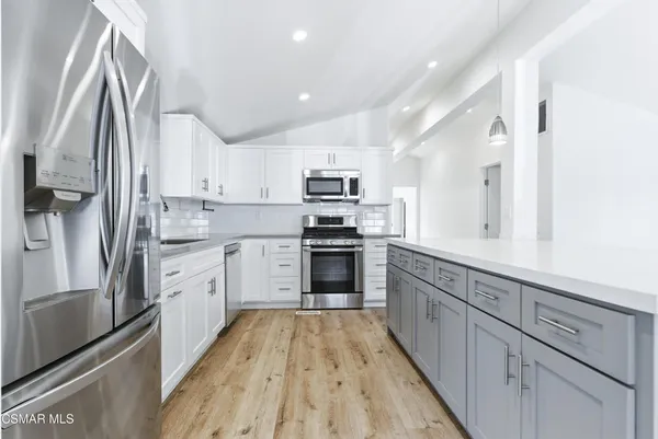 a kitchen with granite countertop a stove top oven sink and cabinets