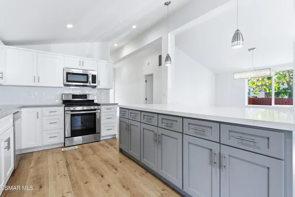 a kitchen with cabinets stainless steel appliances and a sink