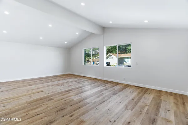 an empty room with windows and wooden floor