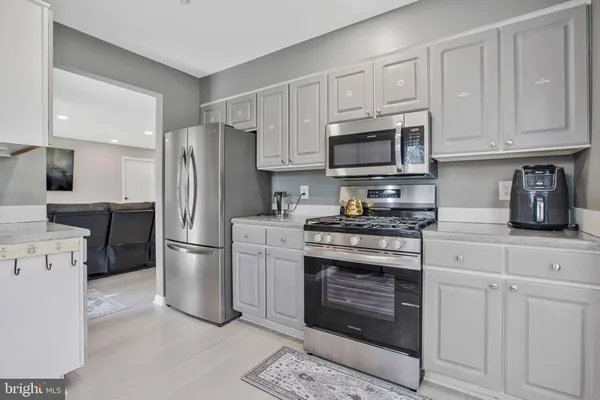 a kitchen with stainless steel appliances granite countertop a refrigerator stove a sink and a microwave