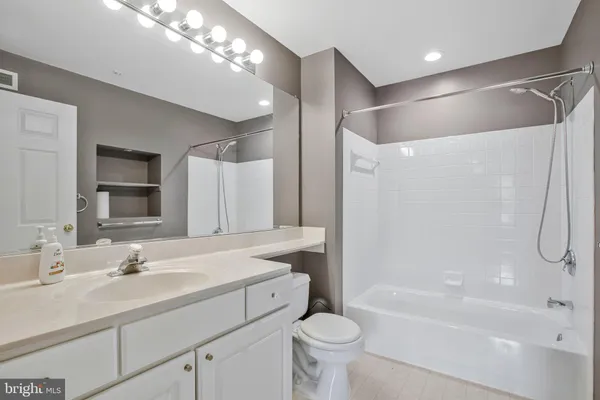 a bathroom with a sink toilet double vanity and bathtub