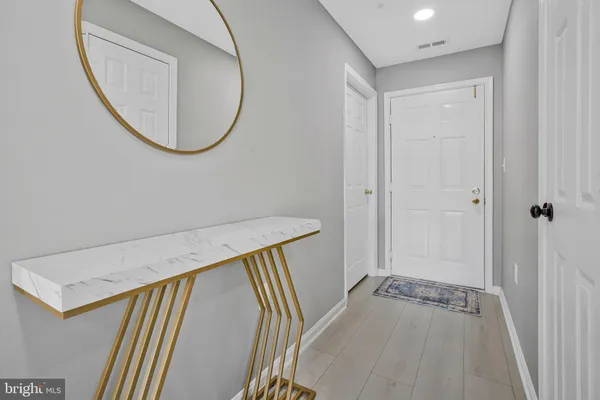 a view of a hallway with wooden floor and entryway