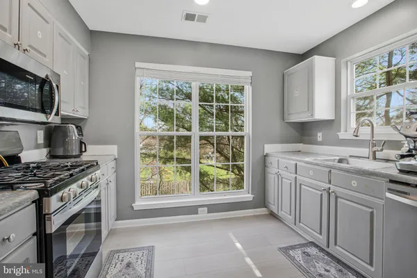 a kitchen with stainless steel appliances a stove sink and microwave