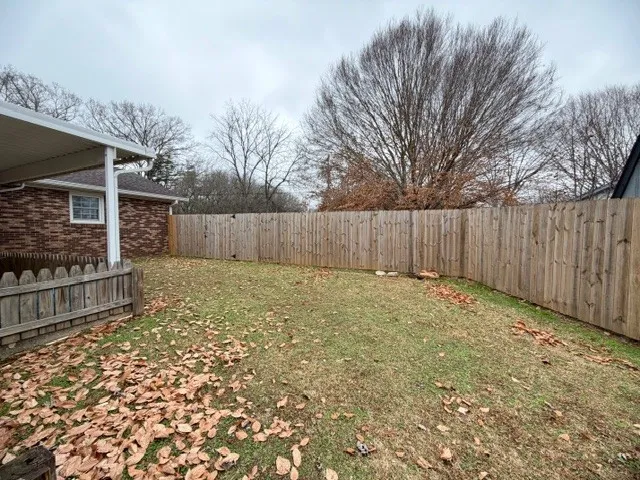 a view of a backyard with wooden fence