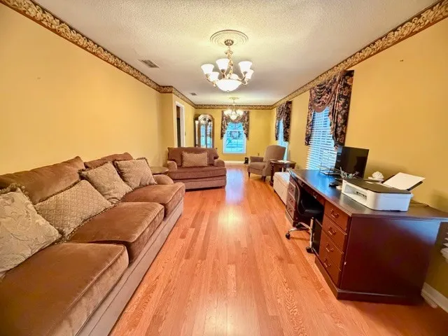 a living room with furniture and a chandelier