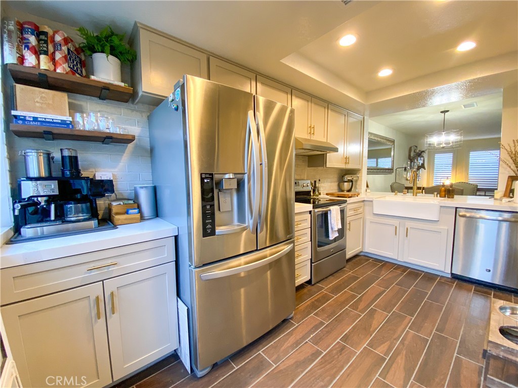 1087 Mesa Bluff Drive Costa Mesa, CA 92627 - Photo 9 of 23 a kitchen with stainless steel appliances a refrigerator sink and cabinets