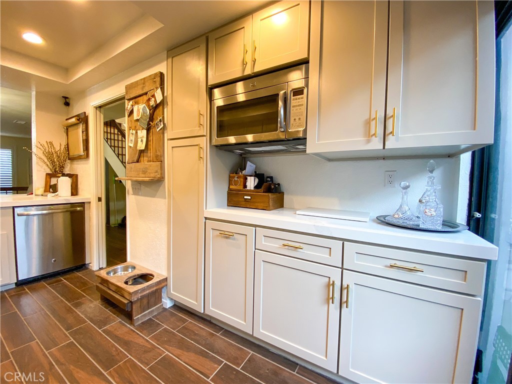 1087 Mesa Bluff Drive Costa Mesa, CA 92627 - Photo 10 of 23 a kitchen with stainless steel appliances a stove and white cabinets