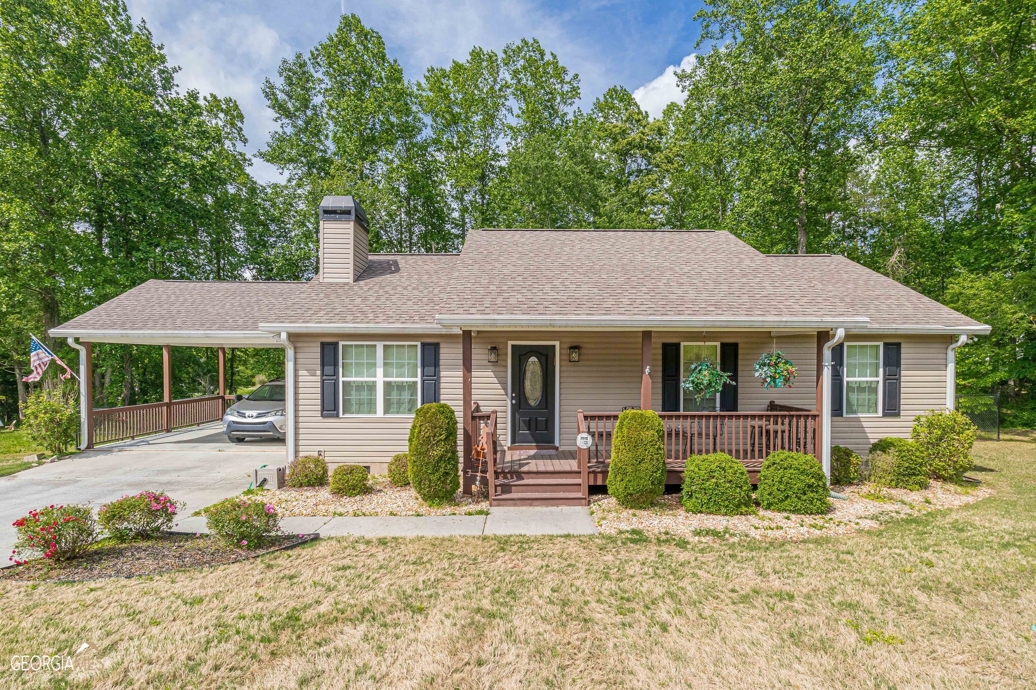 a front view of a house with a yard and potted plants