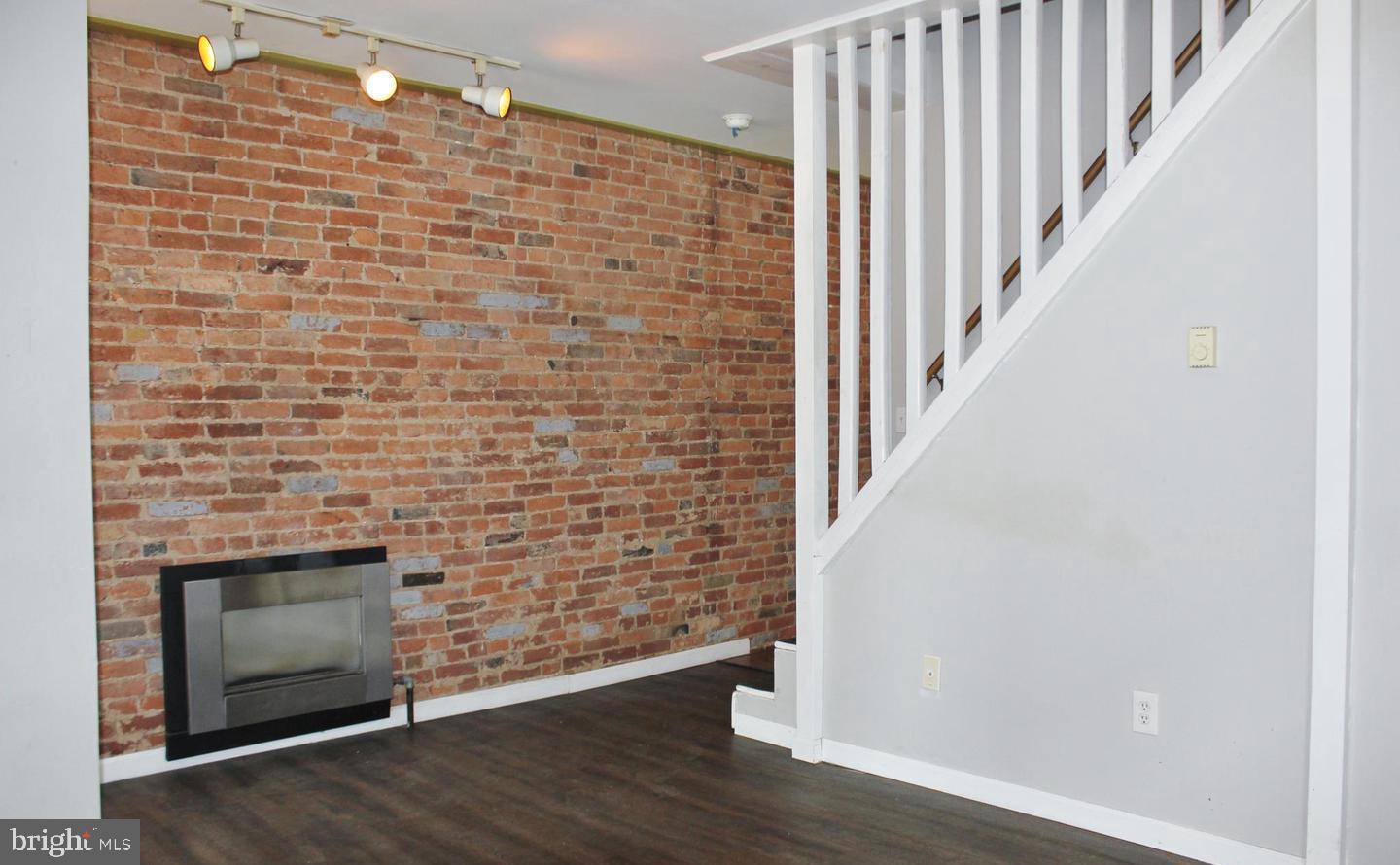 236 North Locust Street Hagerstown, MD 21740 - Photo 3 of 22 a view of an empty room with wooden floor and a fireplace