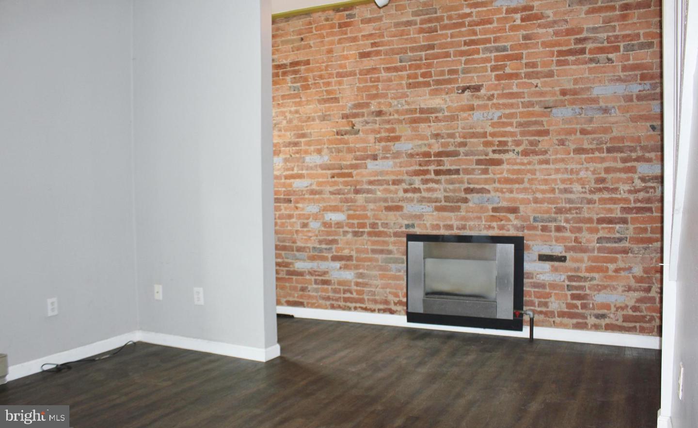 236 North Locust Street Hagerstown, MD 21740 - Photo 6 of 22 a view of an empty room with wooden floor and a fireplace