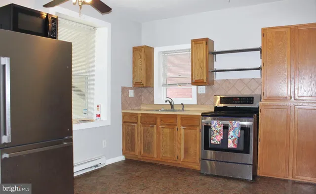 a kitchen with stainless steel appliances granite countertop a refrigerator and a stove top oven