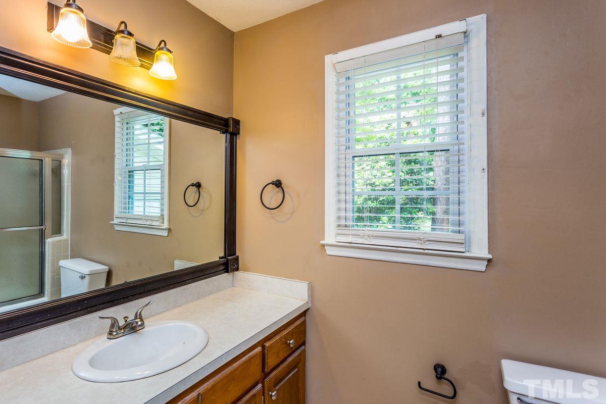 6908 Sandringham Drive Raleigh, NC 27613 - Photo 12 of 21 a bathroom with a sink and a mirror
