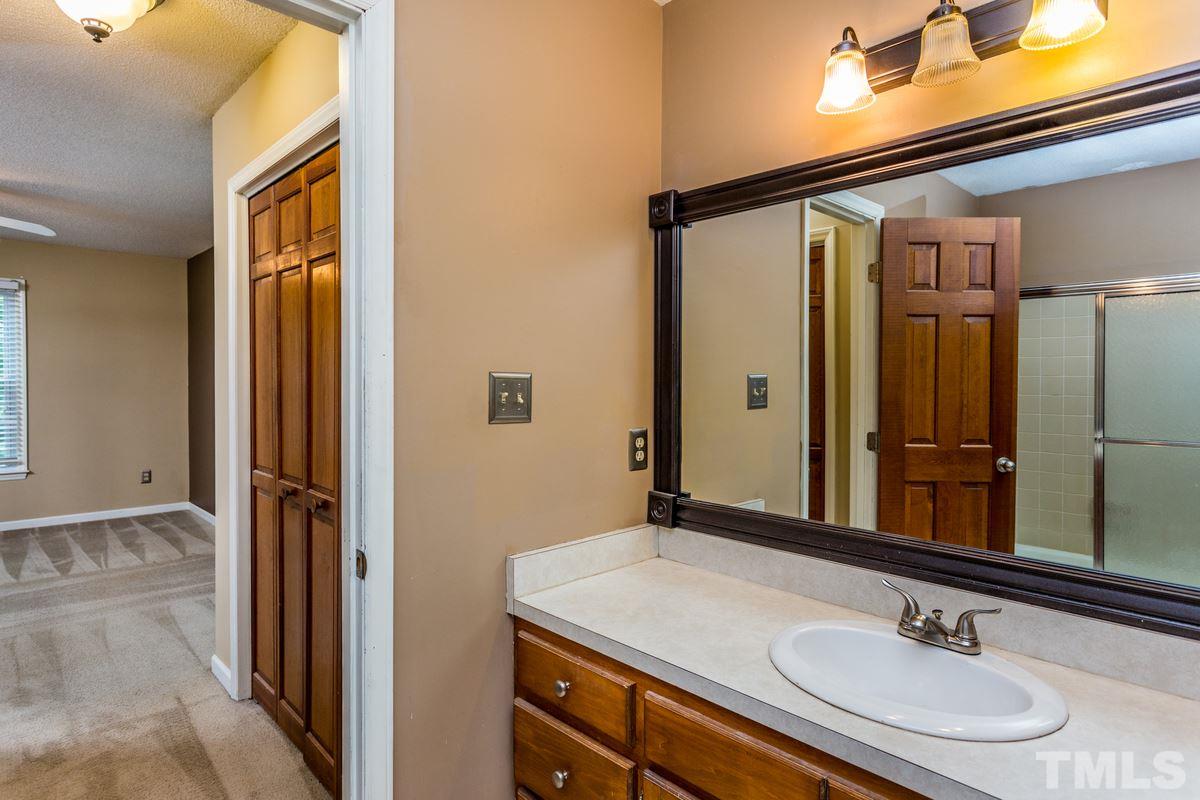 6908 Sandringham Drive Raleigh, NC 27613 - Photo 13 of 21 a bathroom with a sink a mirror and a shower