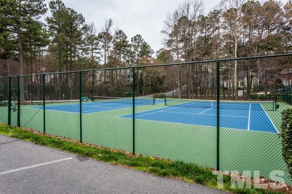 6908 Sandringham Drive Raleigh, NC 27613 - Photo 21 of 21 a view of a tennis court with wooden fence