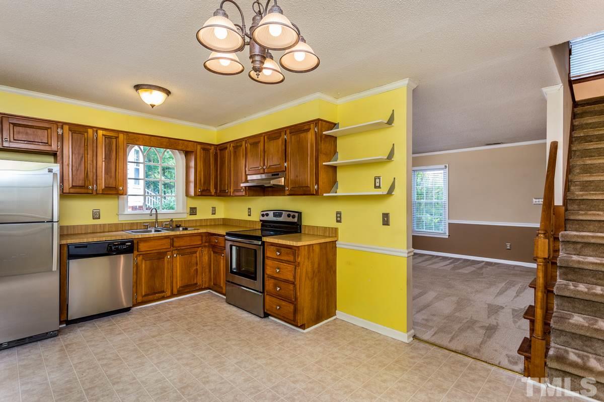 6908 Sandringham Drive Raleigh, NC 27613 - Photo 6 of 21 a kitchen with stainless steel appliances granite countertop a stove refrigerator and cabinets