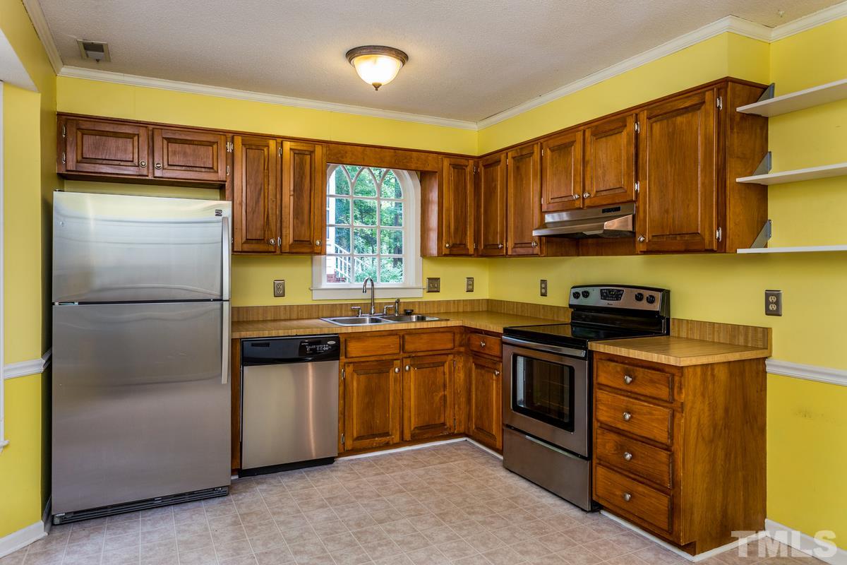 6908 Sandringham Drive Raleigh, NC 27613 - Photo 7 of 21 a kitchen with stainless steel appliances granite countertop a refrigerator sink and cabinets