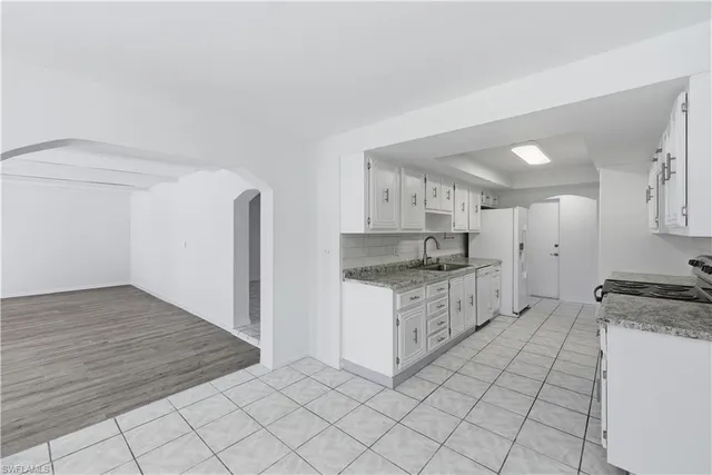 a kitchen with granite countertop white cabinets and white appliances