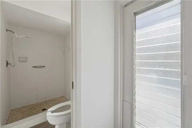 a white toilet sitting next to a shower