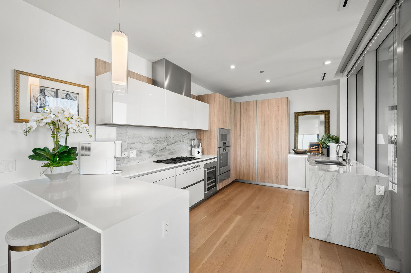 363 East Wacker Drive, Unit 3109 Chicago, IL 60601 - Photo 9 of 23 a large kitchen with stainless steel appliances a large counter top a stove a chimney a sink and dining room view