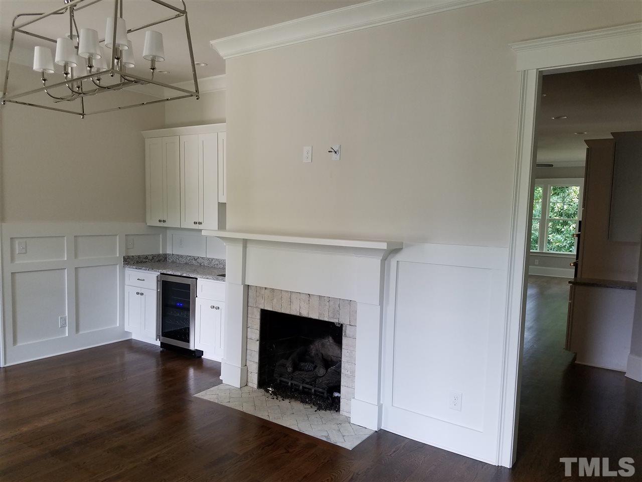 1220 Mitchell Street Raleigh, NC 27607 - Photo 4 of 25 a living room with a fireplace and wooden floor