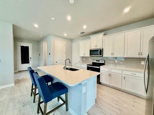 a kitchen with a sink a microwave and refrigerator