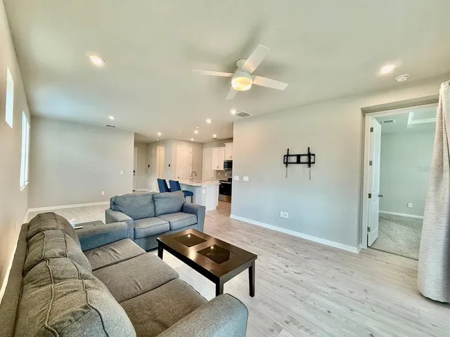 a living room with furniture and a wooden floor