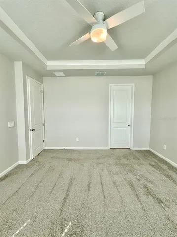 an empty room with a ceiling fan and a window