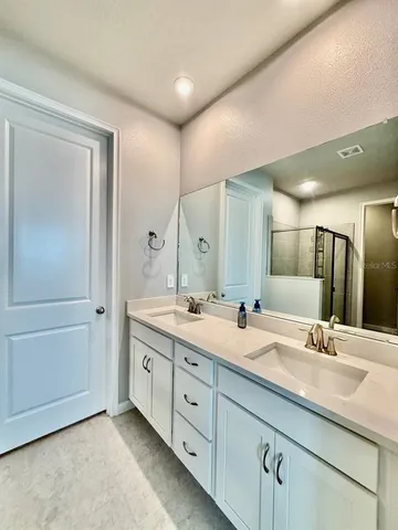a bathroom with a double vanity sink and mirror